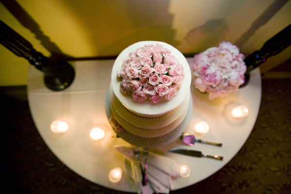 White three tiered cake with pink rose topper - wedding photo by Melissa Jill Photography